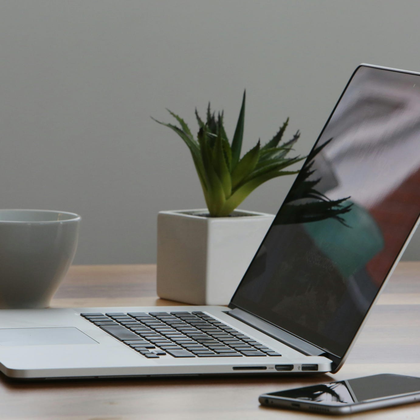 Silver Laptop and White Cup on Table