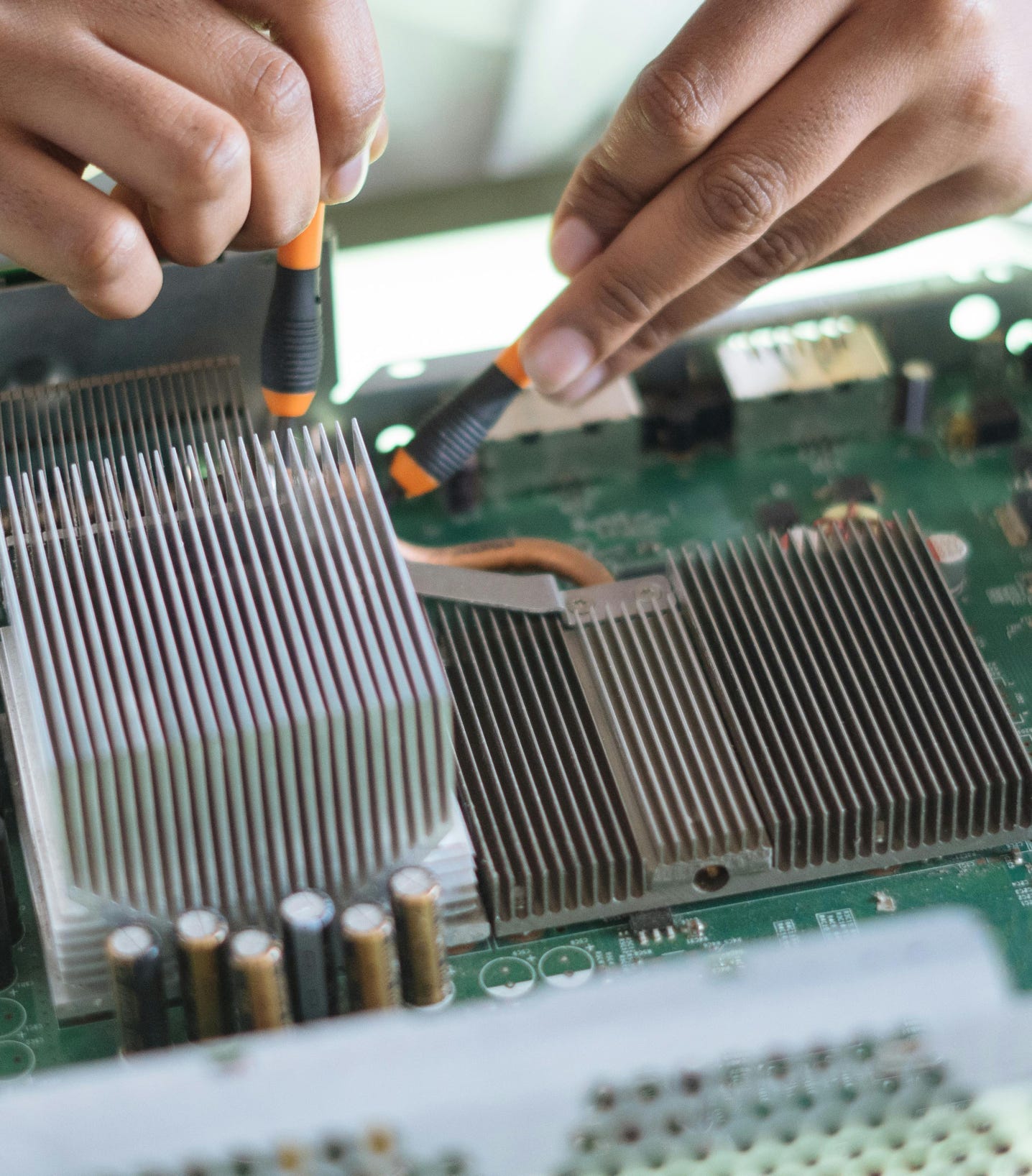 Crop technician checking contacts on motherboard in workshop